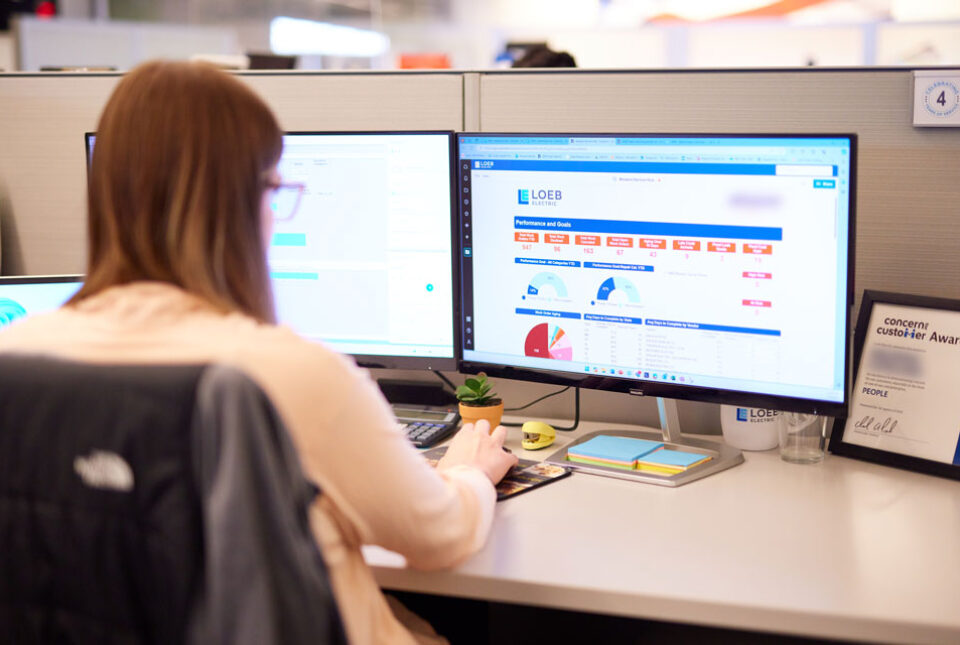 A Loeb Electric project manager overseeing a project dashboard at their desk