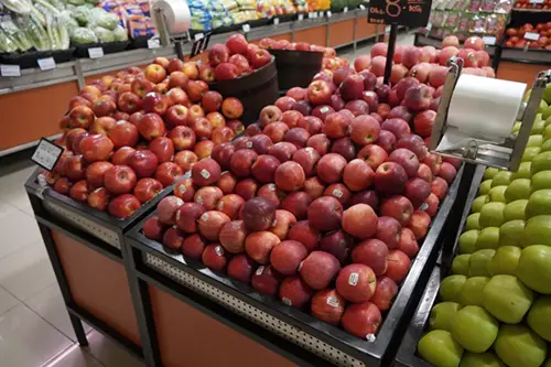 A grocery store display of red apples. Standard LED color rendering dulls their color.