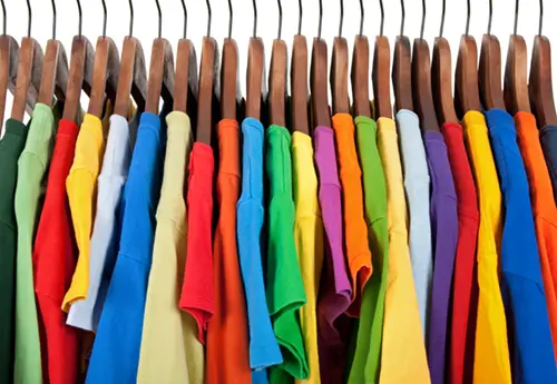 Colorful T-shirts hanging on a display rack. Current's TriGain LED color rendering makes their color more vibrant.