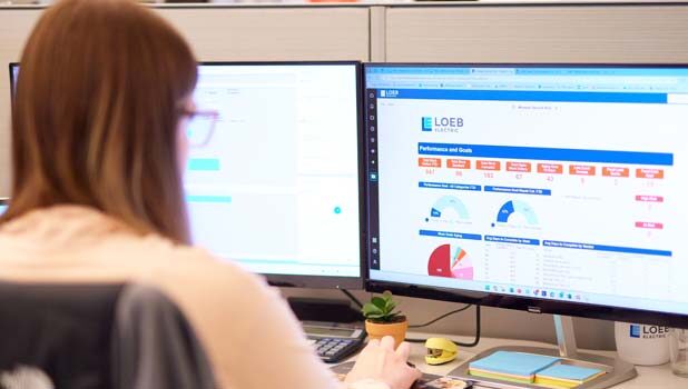 A Loeb Electric project manager looks over a customer dashboard that displays current project statistics